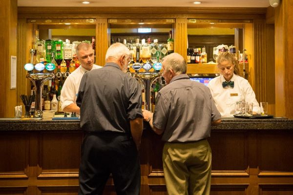Bar staff at the Loch Awe Hotel Bar serving two self-drive customers