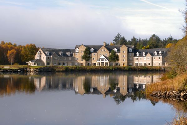 Photo from across the loch of the Loch Tummel Hotel reflecting in the water