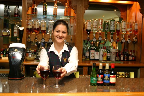 Staff member at the Loch tummel bar serving drinks to customer